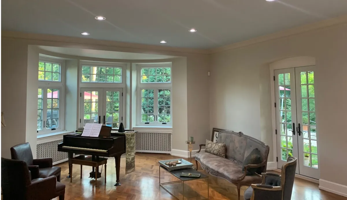 Freshly painted interior hallway with white-trimmed windows and hardwood floors