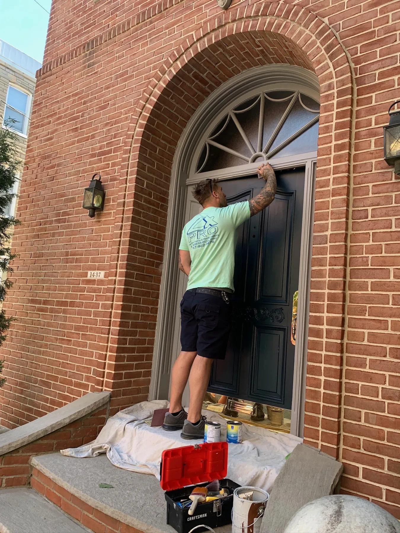 Craftsman applying finish to a historic front entry