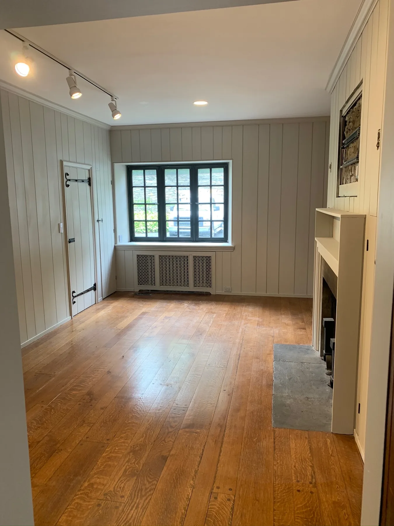 Finished paneled room with restored wood floor