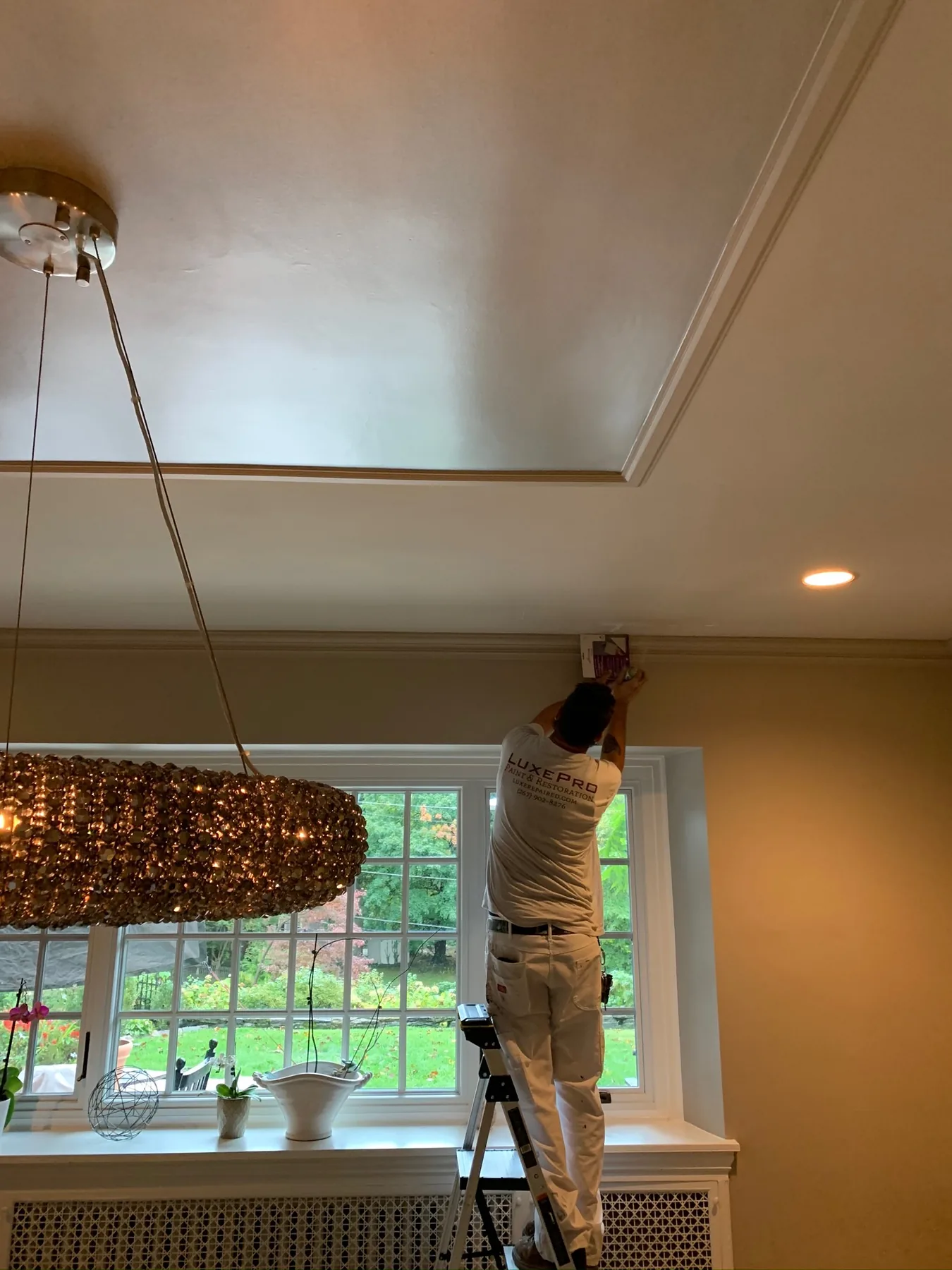 Painter finishing a high interior ceiling